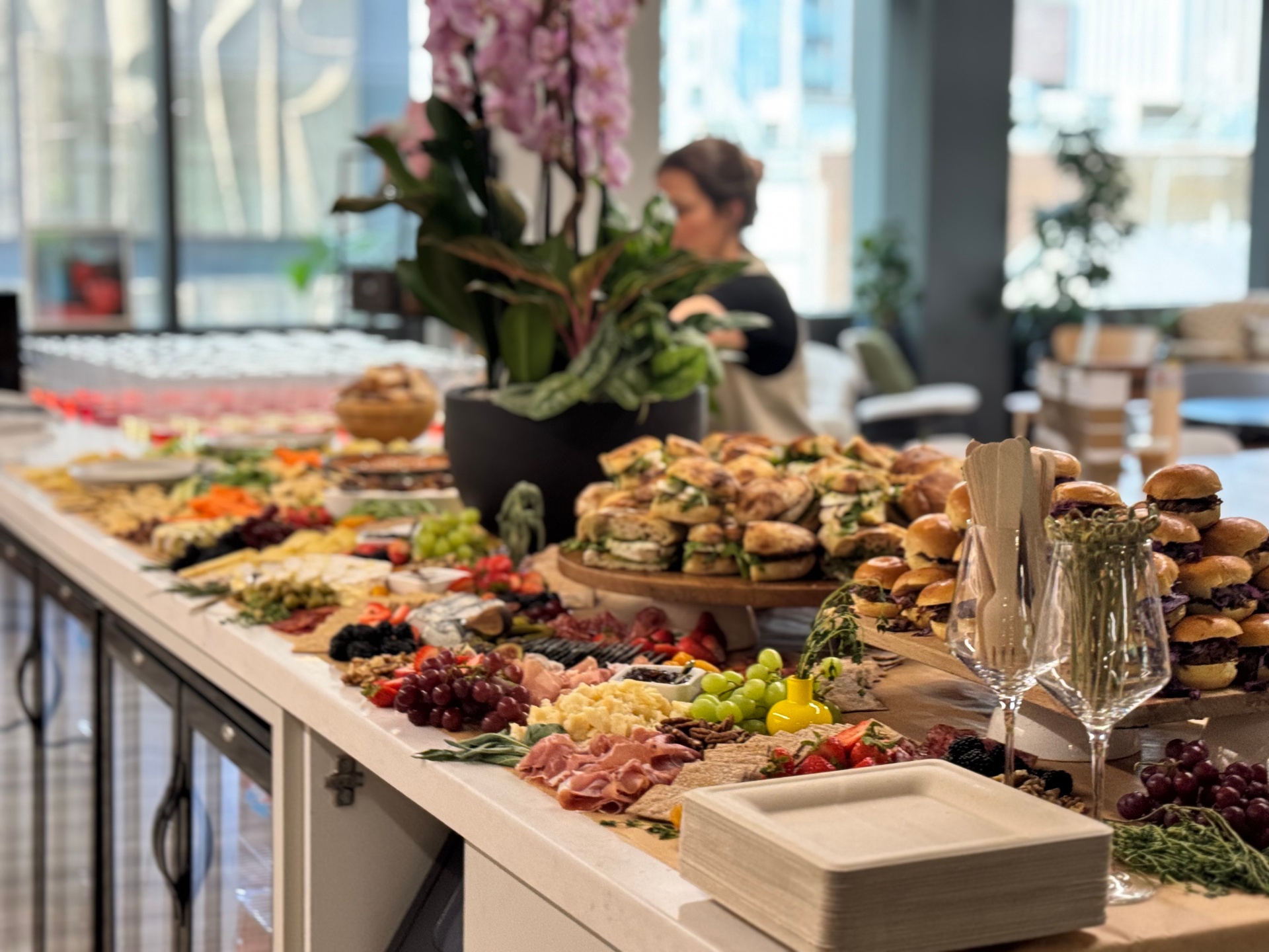 A grazing table spread with sliders, charcuterie, cheeses and fruit